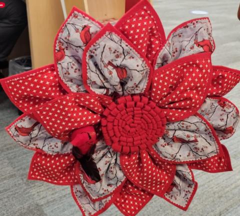 Fabric wreath made with red and gray fabric.