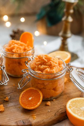 orange sugar scrub in glass jar with wooden spoon