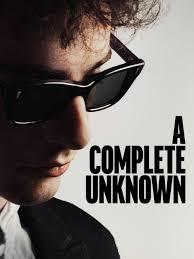 Promotional artwork for the film A Complete Unknown. The image shows a close-up, side-profile view of a man wearing dark sunglasses, partially in shadow. He has curly hair and is dressed in dark clothing. The background is plain and light-colored. Bold black text on the right side of the image reads “A Complete Unknown.”