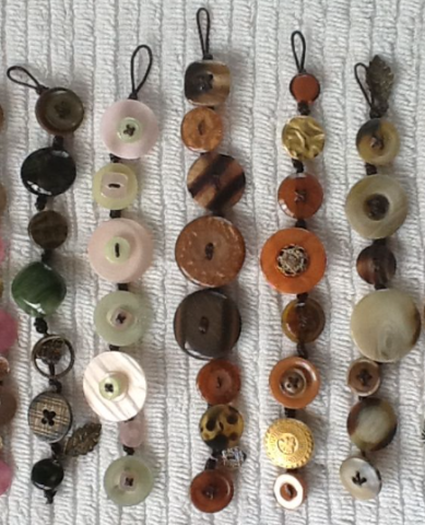 5 bracelets made of neutral colored buttons