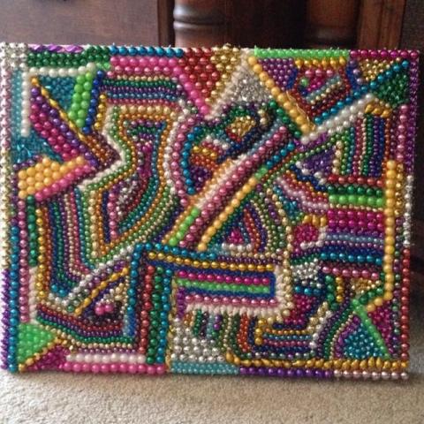 Abstract canvas with Mardi Gras beads of many colors