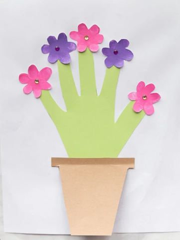  green handprint made out of paper with pink and purple flowers glued to the fingers and pasted to a brown paper pot