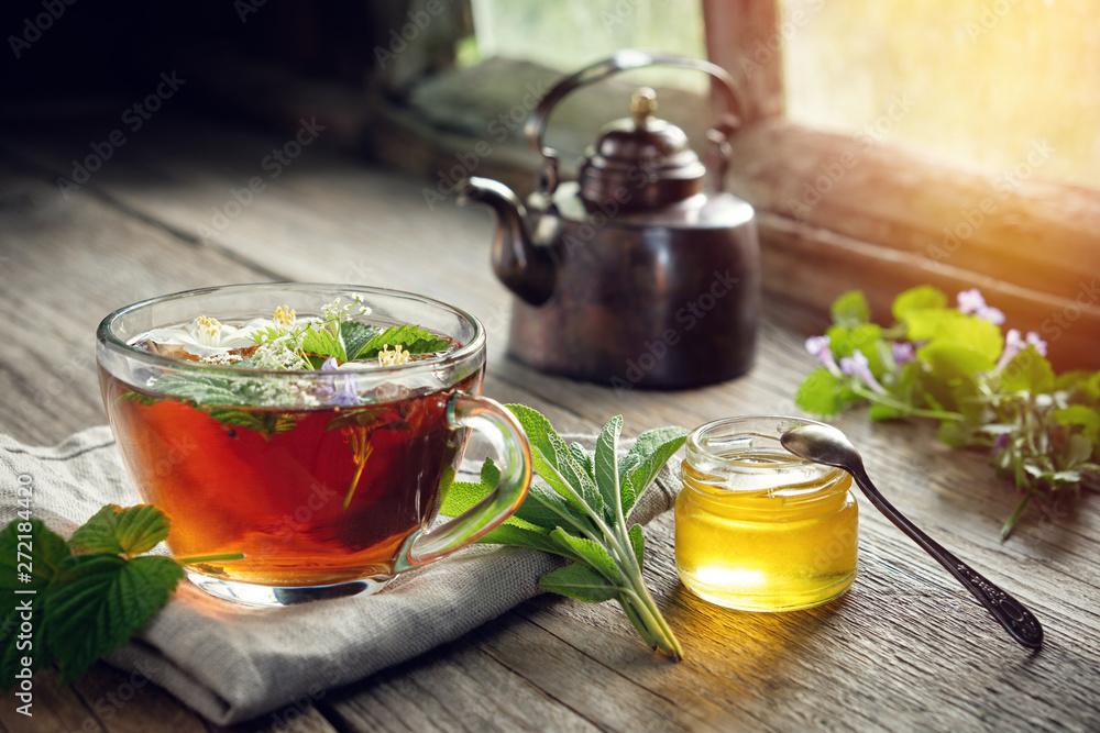 cup of tea with tea pot and honey and spoon