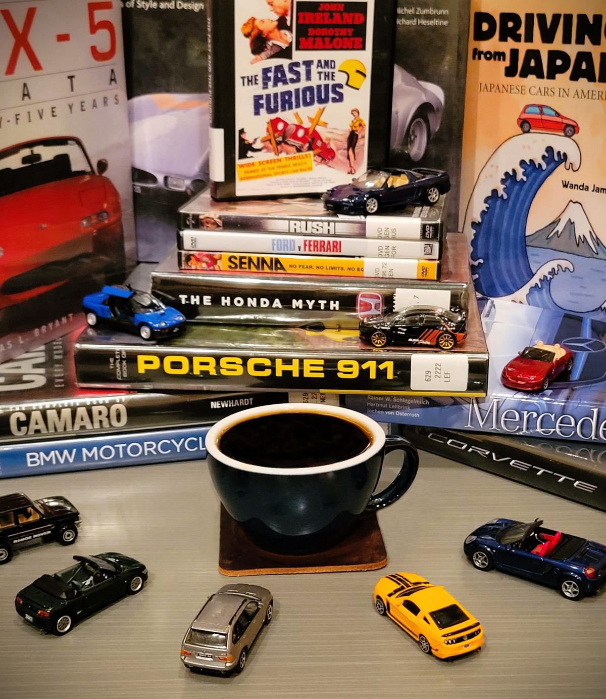 Toy cars, books, and large mug of coffee in the center.